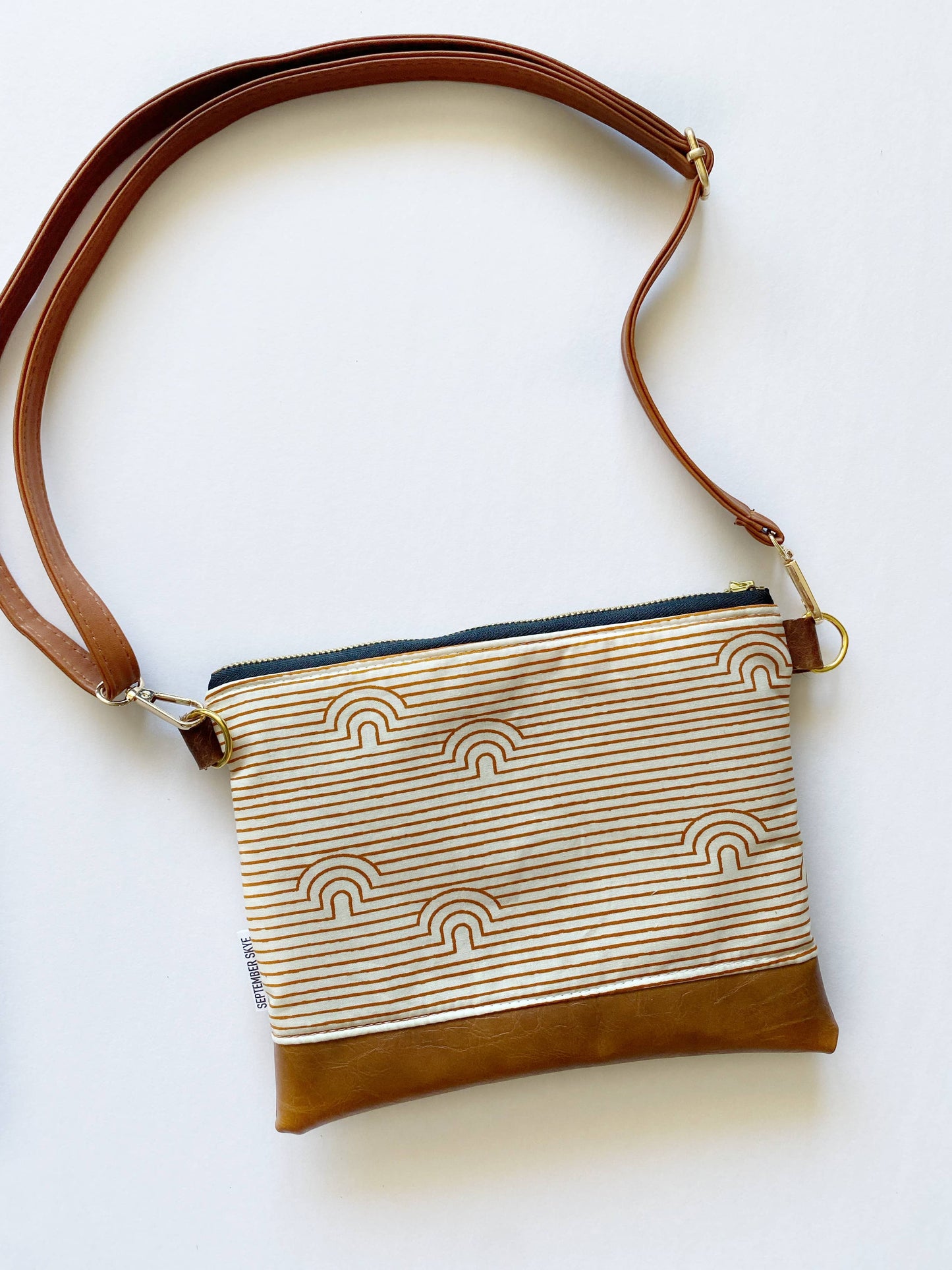 Small crossbody bag in linear caves saddle