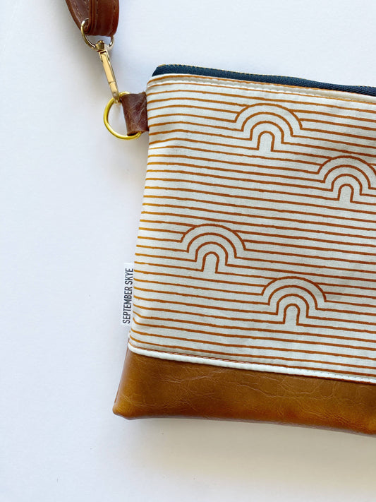 Small crossbody bag in linear caves saddle